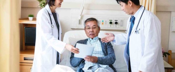 Doctors with patient in hospital room