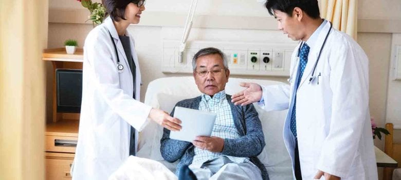 Doctors with patient in hospital room